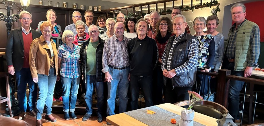 Gruppenfoto der Verwaltungssenioren mit 22 Personen in 3 Reihen im Restaurant aufgestellt.